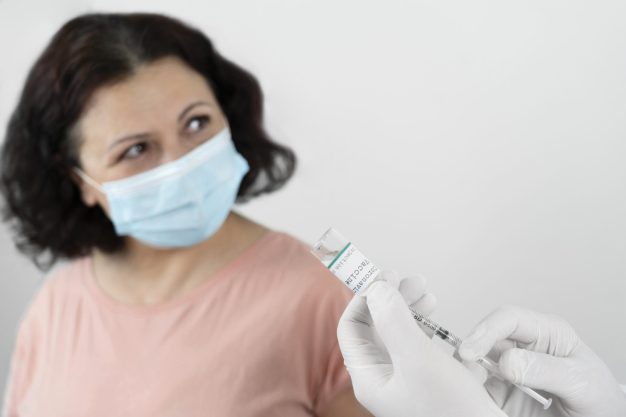 woman-with-medical-mask-getting-vaccine-shot